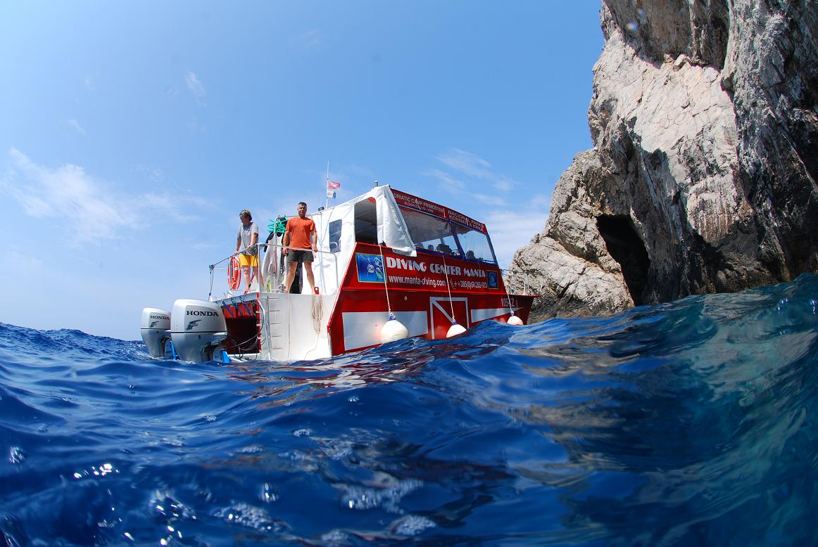 Manta boat next to a rocky dive site on Vis