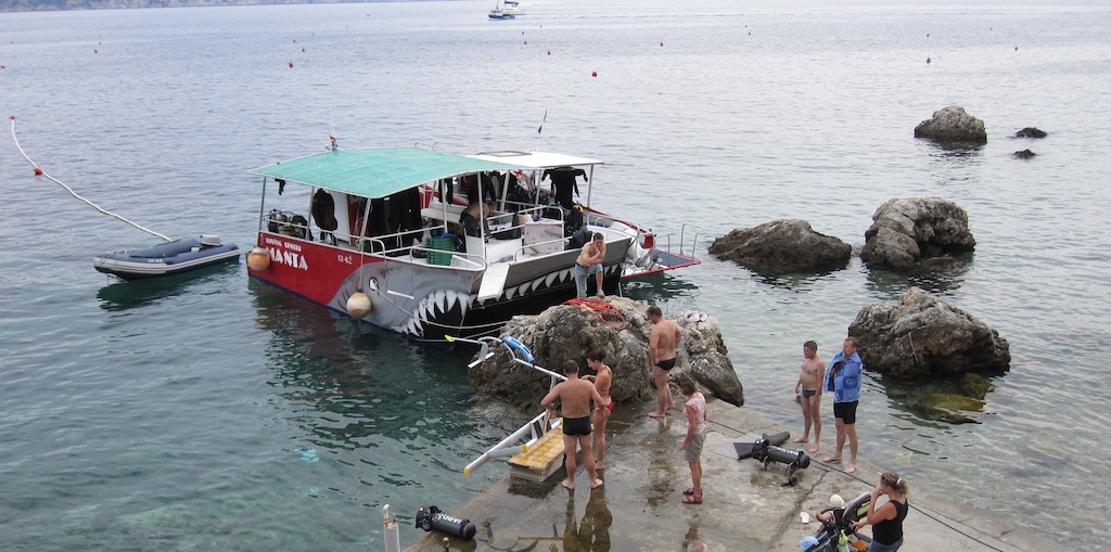 Divers boarding the Manta boat from a small pier on Vis