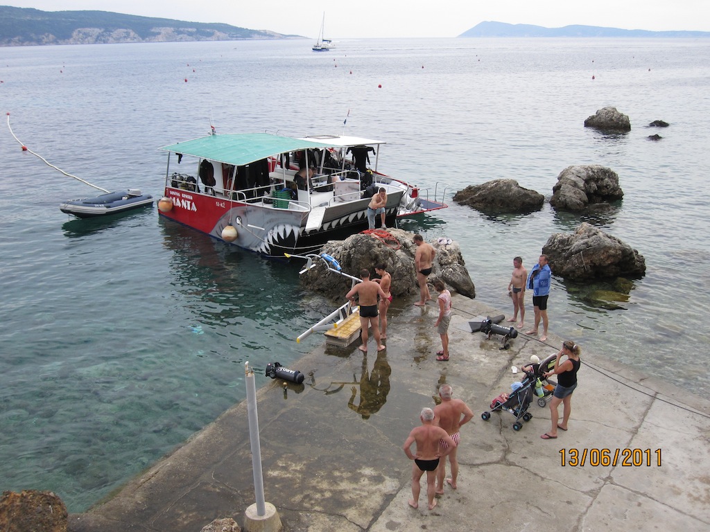 Manta boat and divers gathered on the shore near Vis